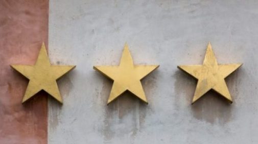 Image Of 3 Gold Five Pointed Stars On A Wall.